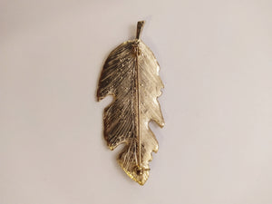 Broche pluma dorada